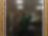 a gold frame with a picture of a man in a green shirt