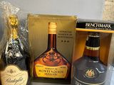three bottles of alcohol and a bottle of wine on a table