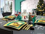 a table set with place settings for four with a christmas tree in the background