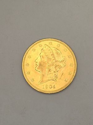 gros plan d'une pièce d'or sur une surface grise