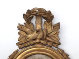 a gold clock with a bird on top of it