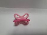 a pink baby pacifier on a white surface