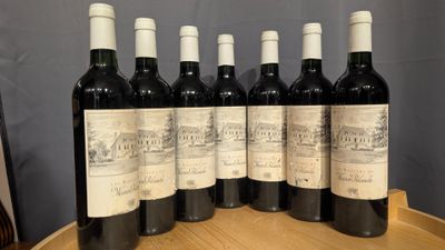 six bottles of wine are lined up on a wooden barrel