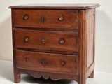 a small wooden chest of drawers on a white background
