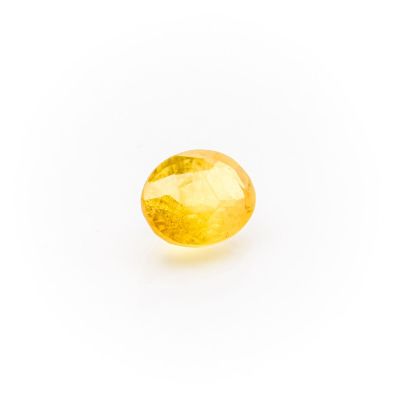 a yellow sapphire stone on a white background