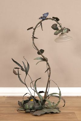 une plante posée par terre, avec une lampe à côté