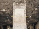 an empty room with a concrete column in the middle of it