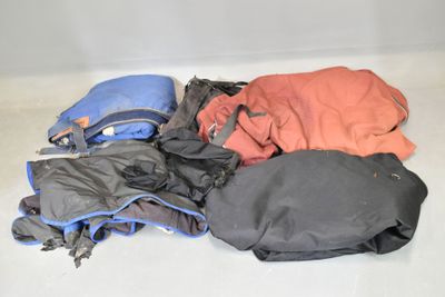 un tas de vêtements par terre, à côté d'un sac à dos
