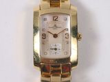 a gold wrist watch with a white dial on a gold bracelet