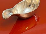 a silver spoon sitting on top of a red car