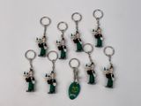 six porte-clés de tailles et de formes différentes, représentant des personnages vêtus de noir et de vert