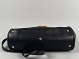 a black leather bag with gold studding and a strap