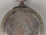 une montre de poche en argent exposée sur une table