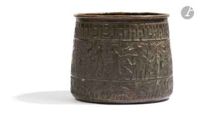 a brown vase with writing on it on a white surface