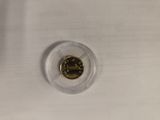 a close up of a coin in a plastic holder on a table