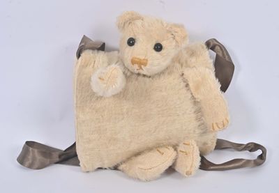 un ours en peluche assis sur un sac