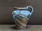 un vase bleu et marron posé sur une table