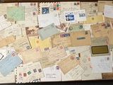 une valise remplie de cartes postales et de lettres, posée par terre