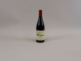 une bouteille de vin rouge posée sur une table blanche