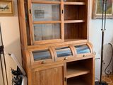 a wooden cabinet with a glass door in a living room