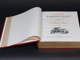 un livre ouvert posé sur une table à côté d'une table noire