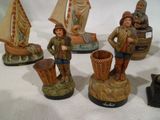 five figurines of people and a boat on a table