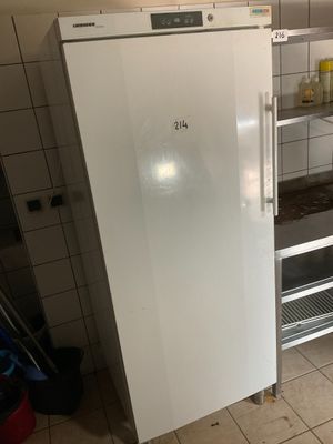 a white refrigerator in a kitchen with a shelf on the wall