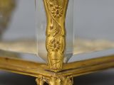 an antique gold plated box with a glass lid on a gray surface