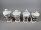 three white ceramic jars with decorative designs on them on a gray surface