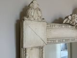 a mirror with a decorative design on the top of it