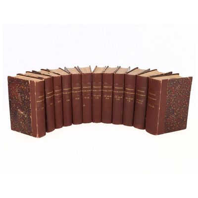 six vieux livres alignés sur une surface blanche