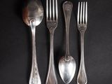 three forks and a spoon on a black background