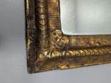 a gold framed mirror on the wall in the room