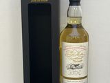 une bouteille de whisky posée à côté d'une boîte noire sur une table