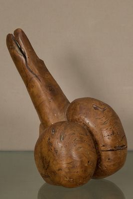 une sculpture en bois représentant un escargot posée sur une table en verre