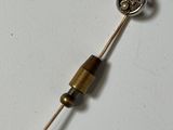 a small metal object with a wooden handle on a white surface