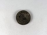 un gros plan d'une pièce de monnaie percée d'un trou au milieu