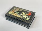 une boîte noire ornée d'une peinture, posée sur une table