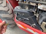 a person holding a wren next to a red tractor