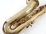 a close up of a gold saxophone on a white surface