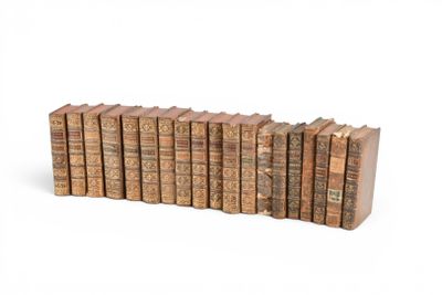 Les vieux livres sont alignés en rangées sur une surface blanche.