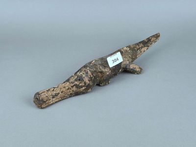 un gros plan sur un alligator en bois avec une étiquette autour du cou
