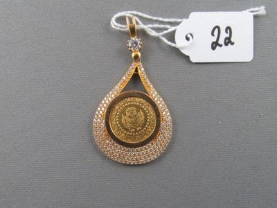 une image représentant un pendentif en or orné d'une pièce de monnaie