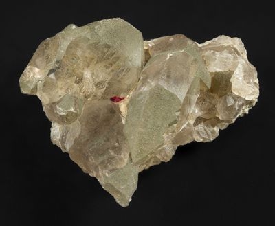 un gros plan sur un amas de cristaux de quartz verts sur fond noir
