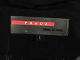 the back of a black jacket with a red and black label on it
