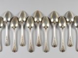 six cuillères en argent sont alignées sur une table