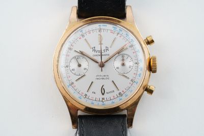 une montre-bracelet en or avec un cadran blanc sur un bracelet noir