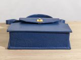 a small blue purse sitting on top of a wooden table