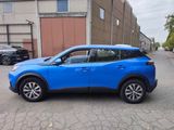 the blue suv is parked in front of a building on the street