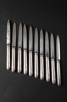six knives are lined up in a row on a black surface